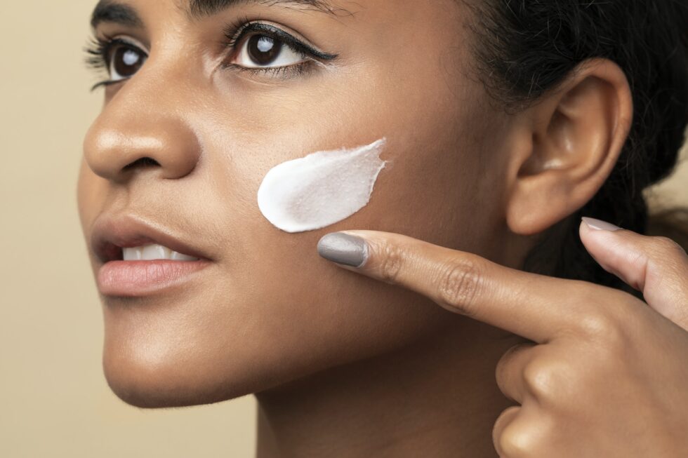 Closeup of a beautiful woman using a moisturizing cream for skincare routine