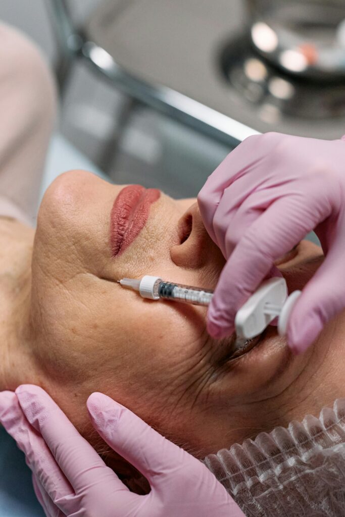 Hands wearing gloves giving a woman an injection